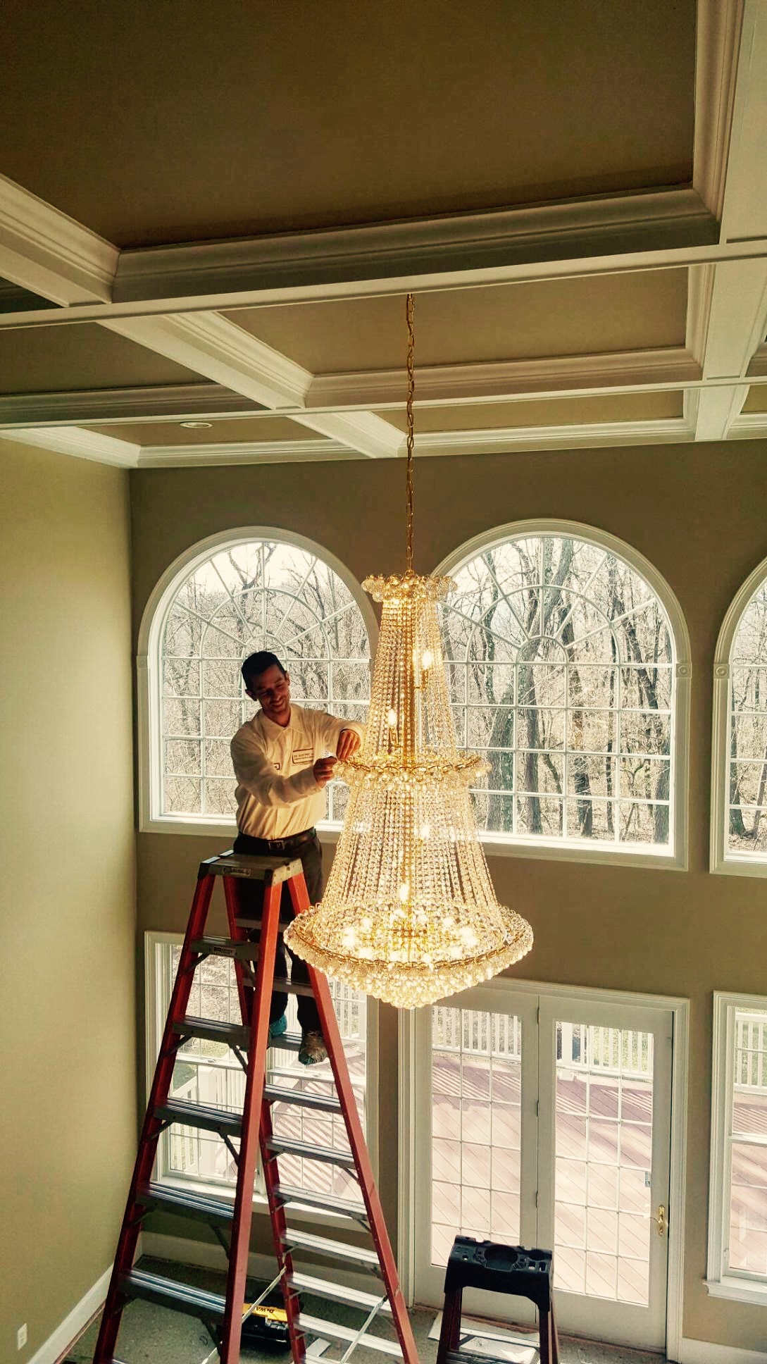 Chandelier installer in London fitting a ceiling light safely